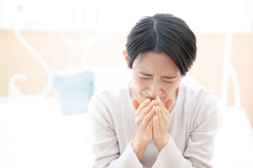 Sneezing Asian woman with a cold
