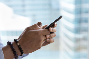 Mobile phone in male hands close up side view shot. Smartphone user man holding digital device, typing on screen, browsing, using gadget for online, Internet communication