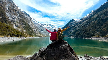  Travelers couple team look on the mountain landscape. Travel and active life concept  as Adventure travel in the mountains region in lake marian  fiordland national park