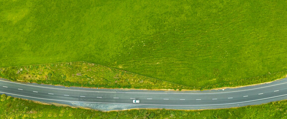 Aerial top view on the road with green field in summer season Nature recovered Environment and...