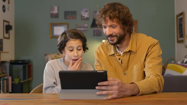 Man and daughter laughing having good time watching digital tablet technology, Family concept