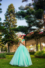 Beautiful young woman dressed in a princess costume in the middle of a park with trees © JuanSt
