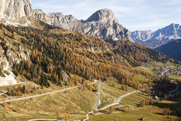 Serpentine narrow asphalt road in sunny autumn day in Italian Dolomites