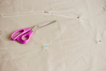 Sewing accessories on fabric pastel color. Process of creating clothes. Workplace of seamstress