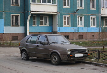 An old gray rusty car is parked in the yard, Iskrovsky Prospekt, St. Petersburg, Russia, December 2022