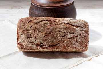 Freshly baked bread leaning on a pot on a white background