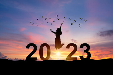 Young woman enjoying and celebrating New Year 2023 with the beautiful sunrise sky and clouds