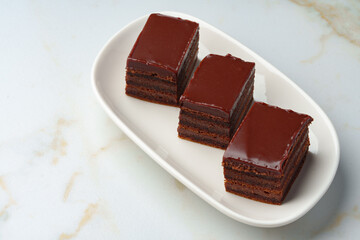 Three piece of chocolate brownie cake on white plate