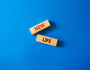 New life symbol. Wooden blocks with words New life. Beautiful blue background. Business and New life concept. Copy space.