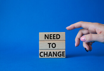 Need to change symbol. Concept words 'Need to change' on wooden blocks. Beautiful blue background....