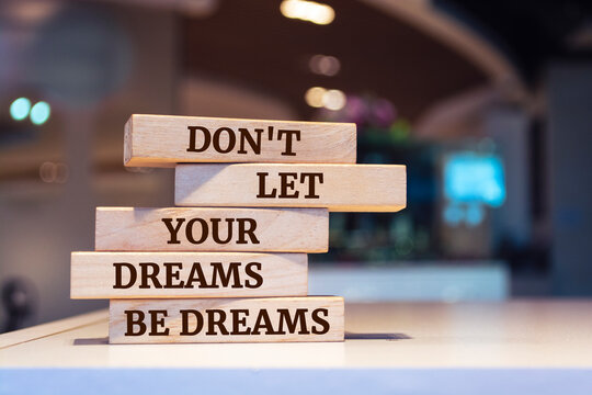Wooden blocks with words 'Don't Let Your Dreams Be Dreams'.