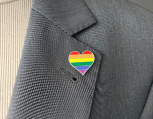 Metal badge with lgbt flag on lapel of man or woman suit