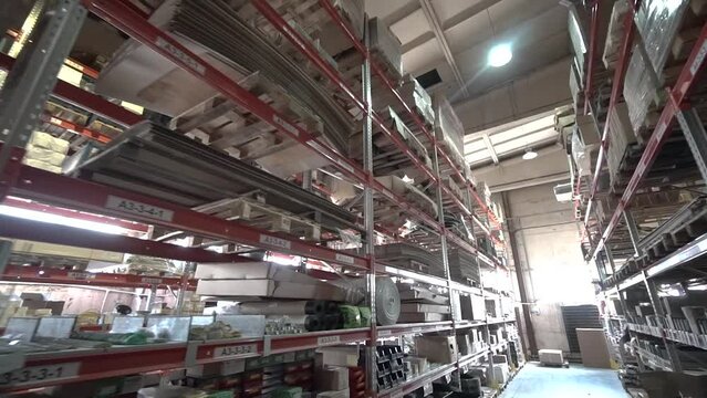 large factory warehouse. store aisles. The camera pans between shelves inside a large store. Delivery to the warehouse. Logistics business and forklift truck to move boxes and goods. freight mail
