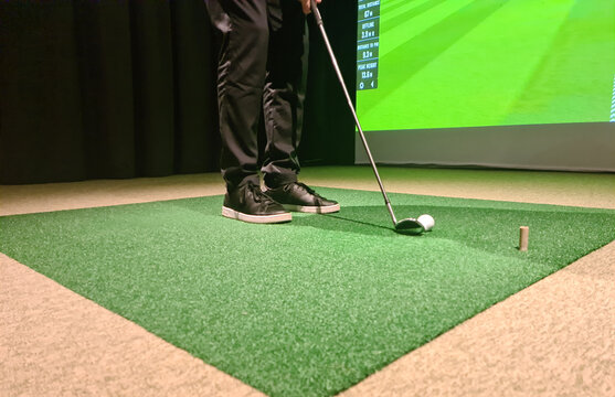 Man Is Playing Golf On Golf Simulator And Getting Ready To Hit