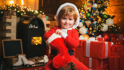 Child got gift in christmas sock. Concept of christmas stocking. Kid boy hold christmas gift.