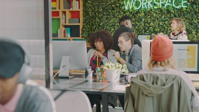 Colleague, creative office and web designer team working together on homepage in a design agency. Workspace, workplace and ux or ui software creativity with startup staff designing project