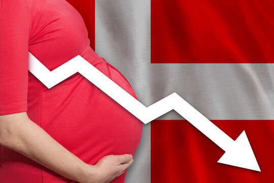 Close up pregnant woman on Danish flag background. Falling fertility rate in Denmark
