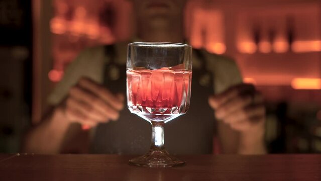 bartender with orange peel preparing cocktail at bar. alcohol drinks, weekend