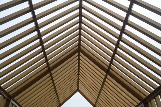 Wooden gable roof structure of the pavilion .Construction of a wood roof beam house from an aerial top view.