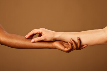 Cropped picture of a multicultural girls touching each other hands.