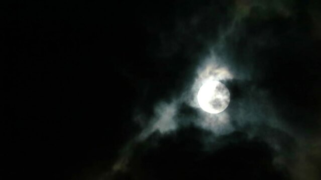 Blur full moon shiny on the dark night cloud with cloud passing