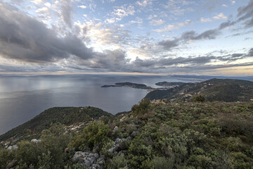 Panorama en bord de mer sur la Côte d'Azur avec comme paysage un ciel menaçant et un coucher de soleil et des falaises