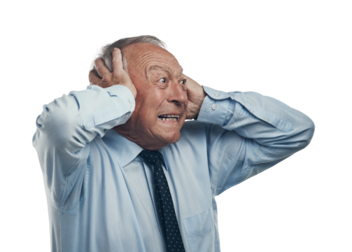 PNG shot of a senior businessman standing against a grey studio background with his head in his hands and looking surprised