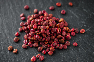 dry aromatic sumac spice on a black stone background