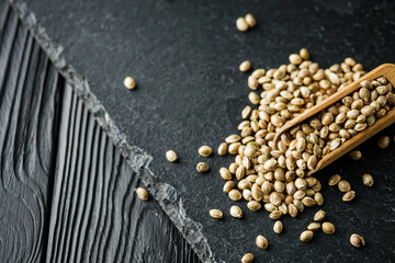 natural hemp seed on black stone background