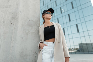 Pretty urban business woman hipster with cap and fashion sunglasses in blazer, top and shorts...