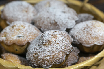 Homemade cupcakes sprinkled with powdered sugar. Muffins - delicious pastries. Delicious dessert on the table - homemade muffins. Portioned cupcakes. Simple muffin.