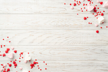 Valentine's Day concept. Top view photo of heart shaped candies on white wooden table background...