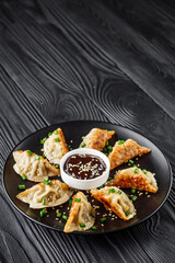 delicious fried gyoza dumplings on a black plate