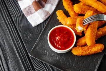 crispy fresh chicken strips on a black rustic wooden background