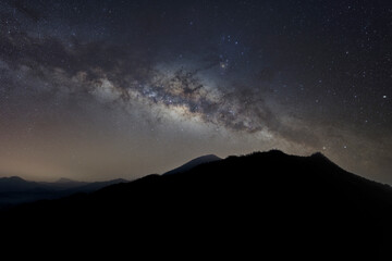 panorama mountain silhouette and blue night sky milky way and star on dark background. universe called,nebula and galaxy with noise and grain. Cassiopeia is a constellation in the northern sky. 