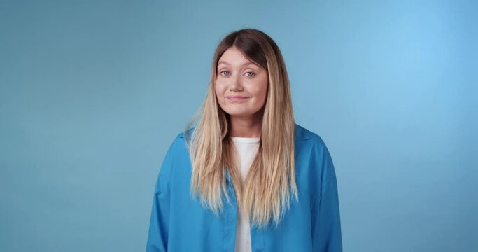 Confused young woman on light blue background