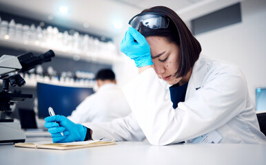Scientist, headache stress and woman writing in notebook for research, planning report or working...