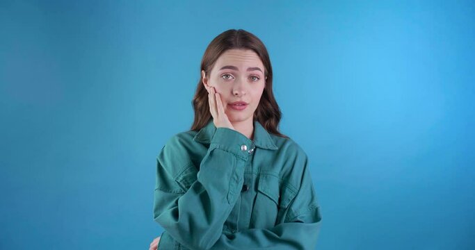 Young woman doing facepalm on light blue background