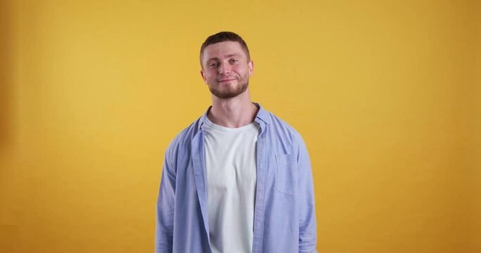 Confused bearded young man on yellow background