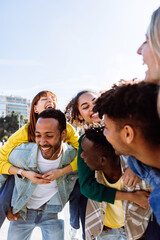 Multiracial friendship with young diverse people having fun together outdoors