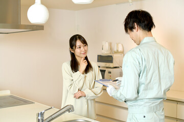 Fototapeta premium キッチンで会話をする男性作業員と女性客