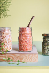 Vegan protein source. Peas, lentils and mung bean in glass on green background. Healthy vegetarian food and lifestyle.