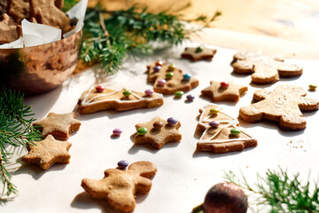 Fototapeta na wymiar Glazed christmas gingerbread cookies a shape of gingerbread man,christmas tree and star,decorated with colorful sugared almonds.Baking homemade pastries.Christmas and New Year traditions festive food.