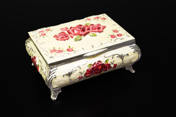 beautiful multi-colored metal jewelry box stands on a black background in a closed form