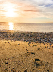 beautiful sea sunrise on a rocky sea coast with calm water , amazing cloudy sky and reflection on water surface