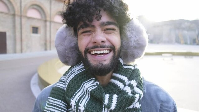 Happy man wearing winter clothes laughing at camera