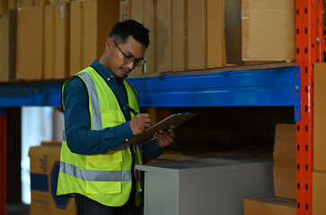 Warehouse worker using digital tablet checking stock on shelves in a retail warehouse