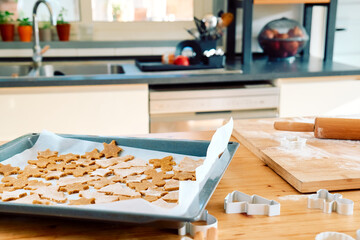 Baking sheet with christmas gingerbread cookies a shape of gingerbread man, christmas tree and star in the kitchen. Baking homemade pastries. Christmas and New Year traditions festive food.