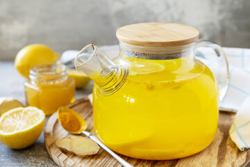 Healthy organic vegan drink. Antioxidant ginger turmeric lemon tea with honey on a stone table. Winter tea, Immunity boosting drink.
