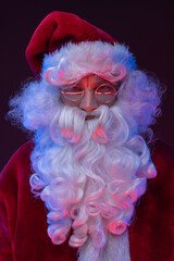 Studio shot of elderly santa claus dressed in red clothes and hat.